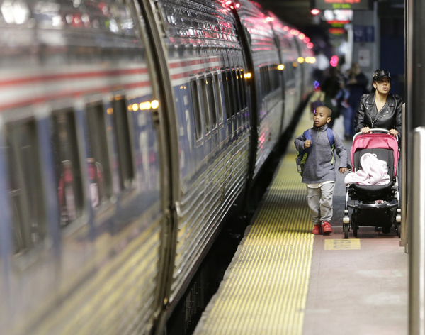 Passengers board a train at Penn Station in New York City.