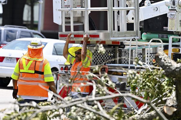 Workers clear debris from city streets in Houston on Wednesday after Hurricane Beryl slammed into Texas, knocking out power to nearly 3 million homes and businesses. 