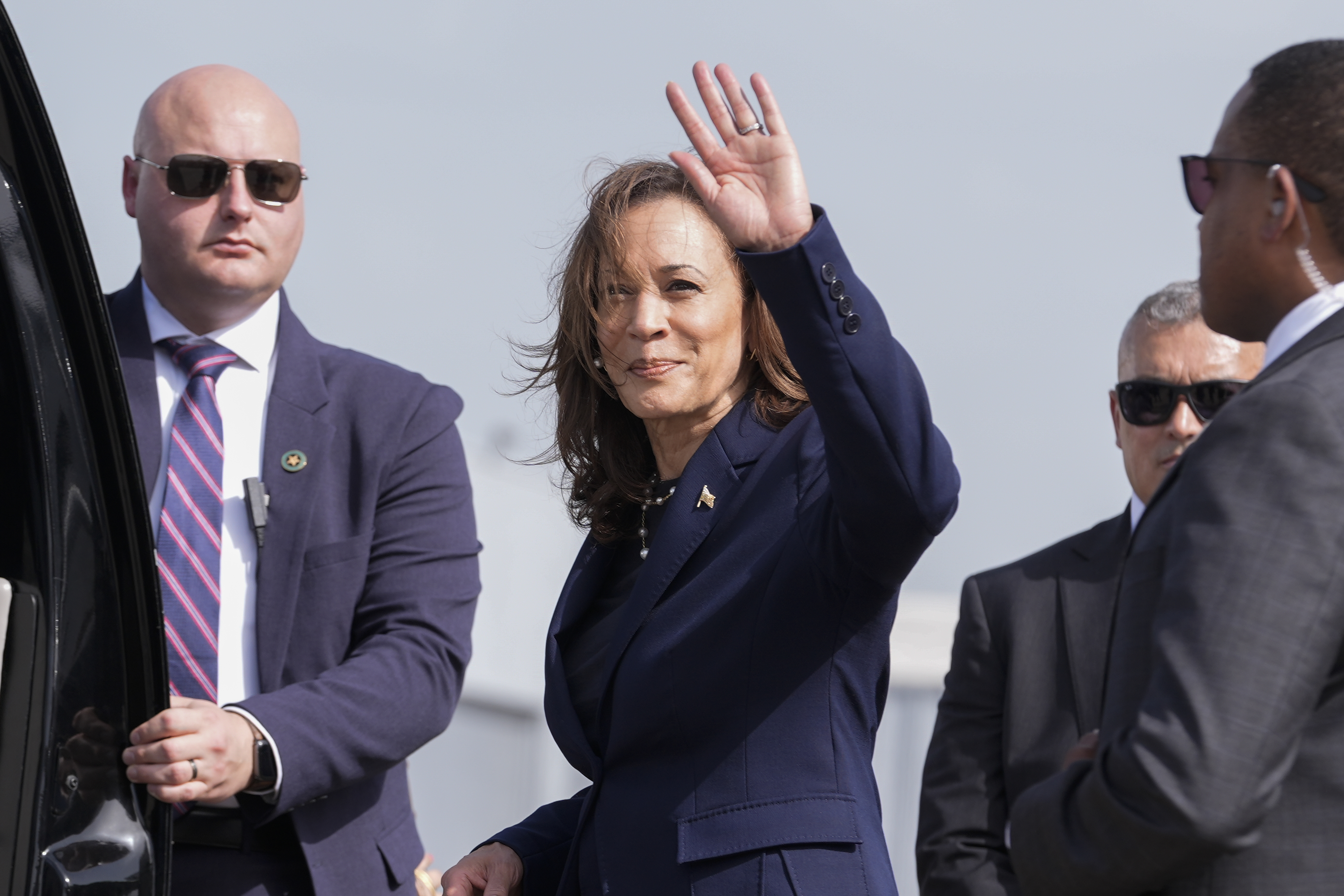 Vice President Kamala Harris waving as she walks across the tarmac during her arrival, Wednesday, July 31, 2024, in Houston.