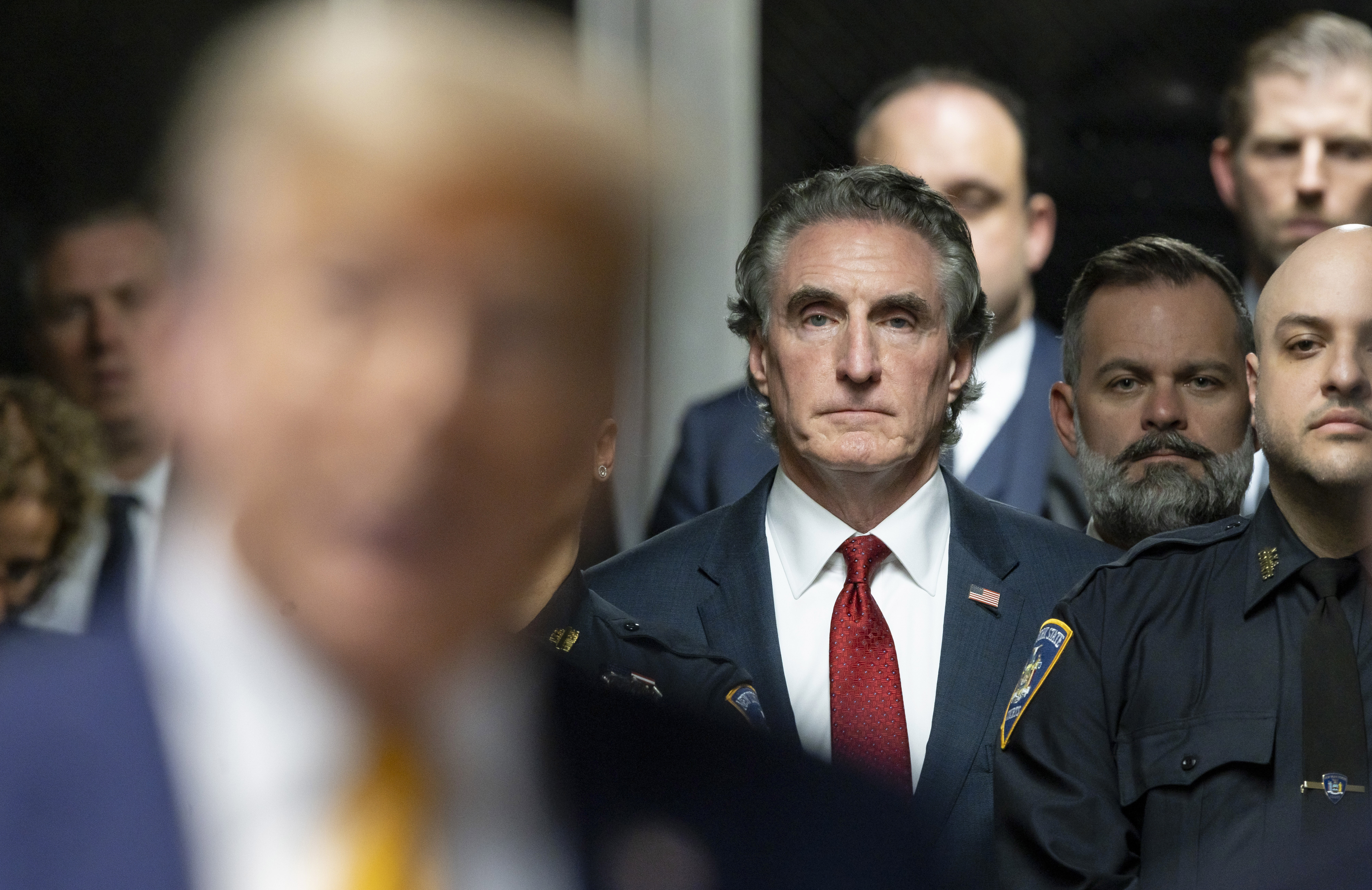 Republican North Dakota Gov. Doug Burgum listens as former President Donald Trump, in foreground, talks to reporters at Manhattan criminal court on May 14 in New York.