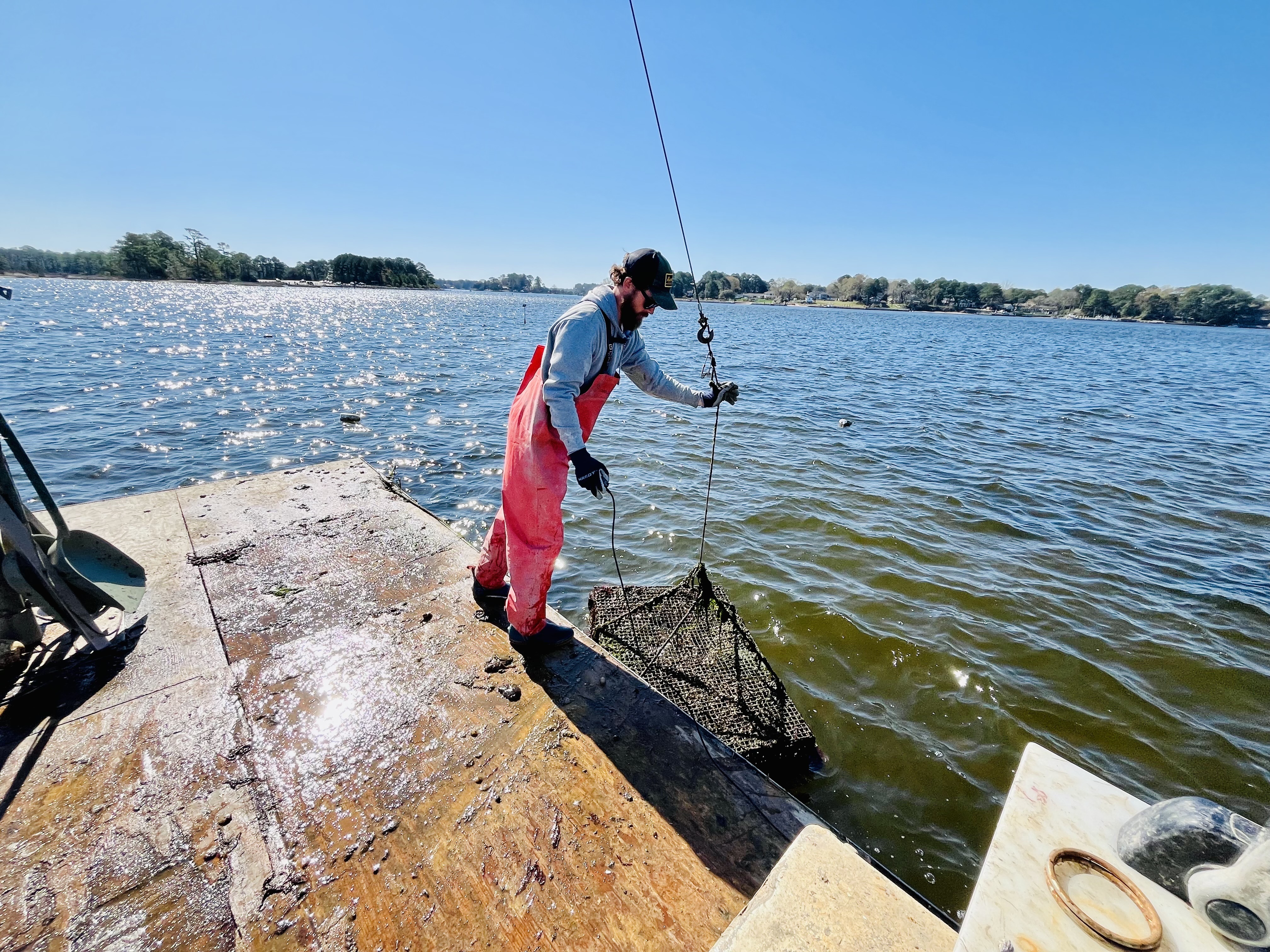 Joey Carmack guides one of his cages before landing it on his rig.