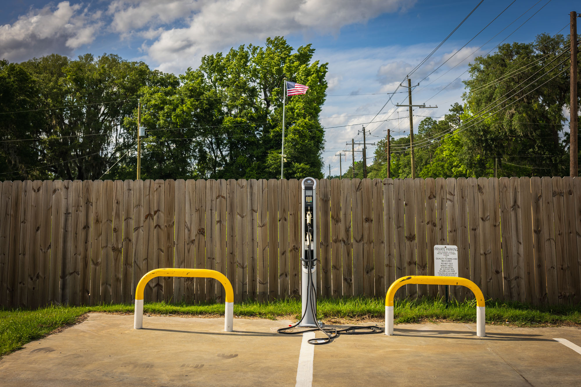 An electric vehicle charging station is pictured in a parking lot.